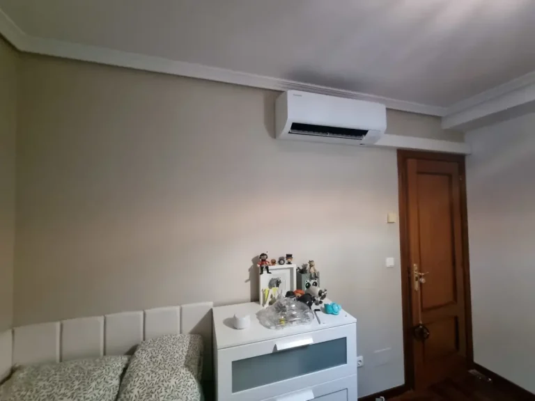 Split de aire acondicionado instalado en un dormitorio en Cangas con los tubos y desagües integrados en una canaleta técnica recta y estéti