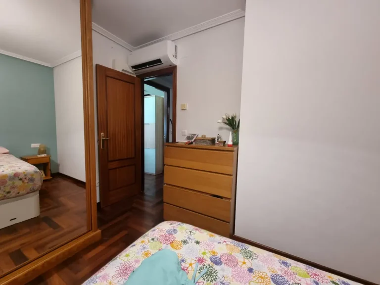 Instalación de aire acondicionado sobre la puerta de una habitación en Cangas, optimizando la caída para el desagüe por gravedad.