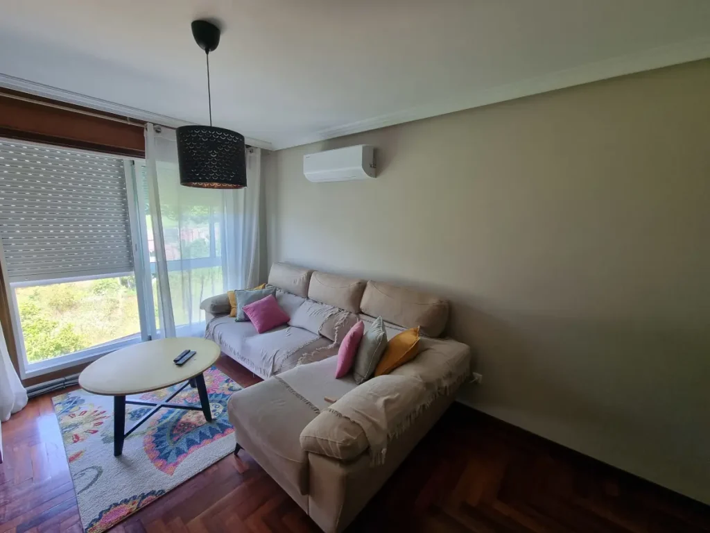 Unidad interior split de aire acondicionado instalada en la pared del salón de un piso en Cangas.