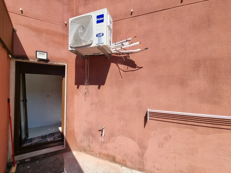Instalación de aire acondicionado en Bueu Unidad exterior Haier 4x1 instalada en la pared de un patio en Bueu con las conexiones frigoríficas preparadas.