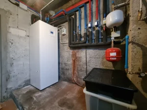 Sala técnica de aerotermia Hitachi R290 completamente terminada con aislamiento negro e interacumulador de 220L